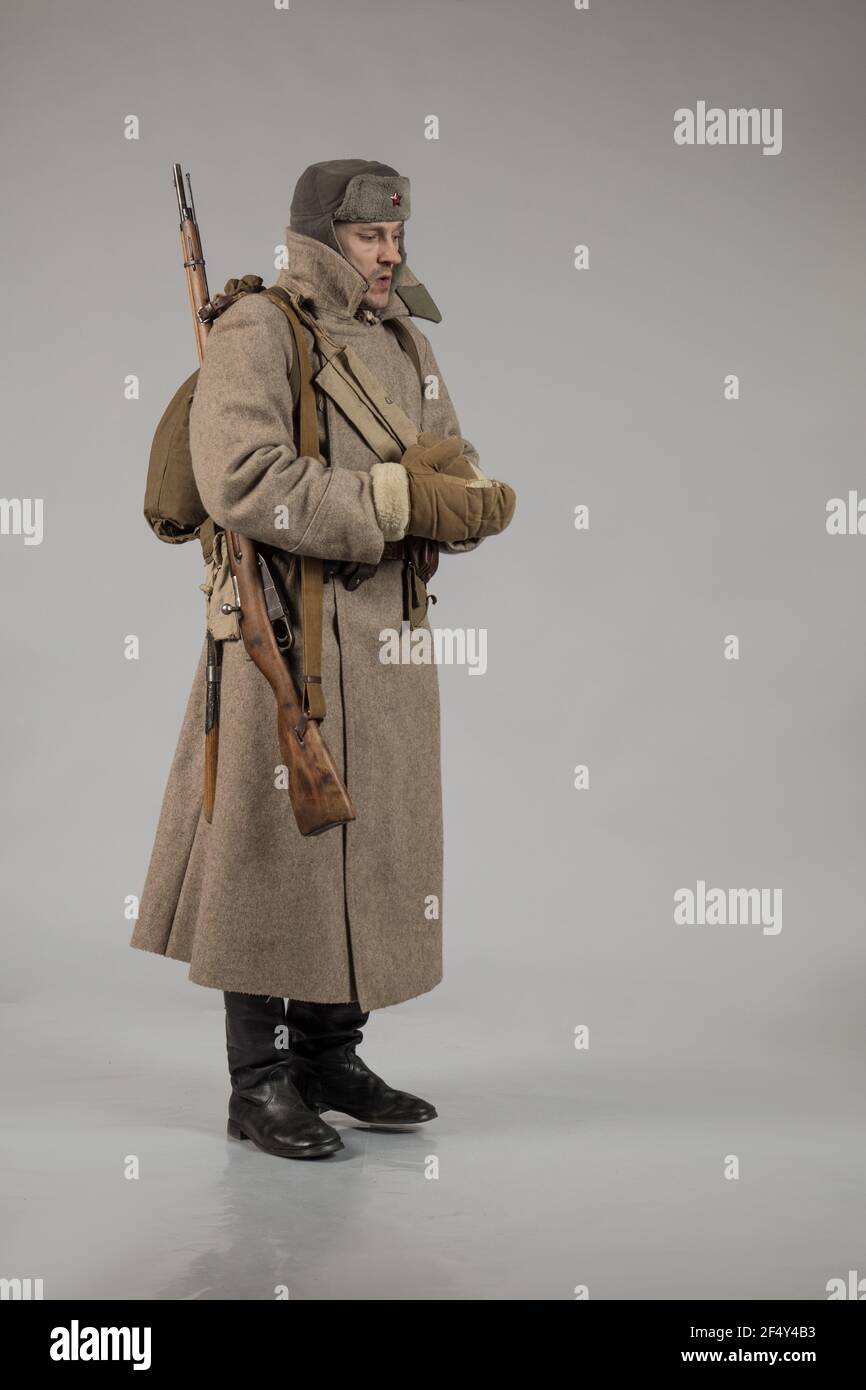 Attore maschile in uniforme invernale un soldato russo dell'Armata Rossa,  un periodo del 1942 la seconda guerra mondiale, posando su uno sfondo  grigio Foto stock - Alamy