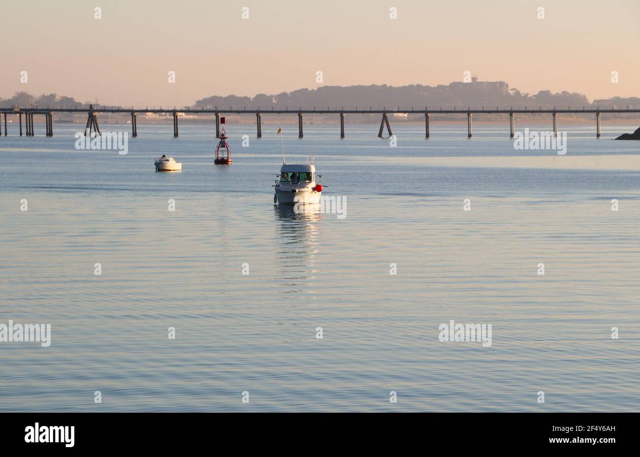 Piccole barche da pesca nella baia di Santander Cantabria Spagna con il molo di gas di petrolio liquido dietro la primavera del sole di inizio mattina Foto Stock