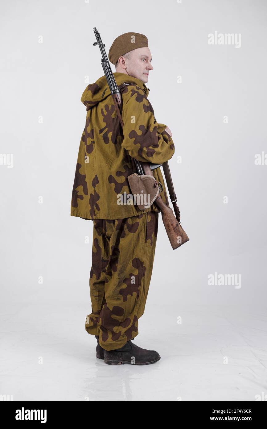 Attore in una vecchia divisa militare e camuffamento cecchino vestiti da markman di un soldato dell'esercito sovietico durante la seconda guerra mondiale Foto Stock