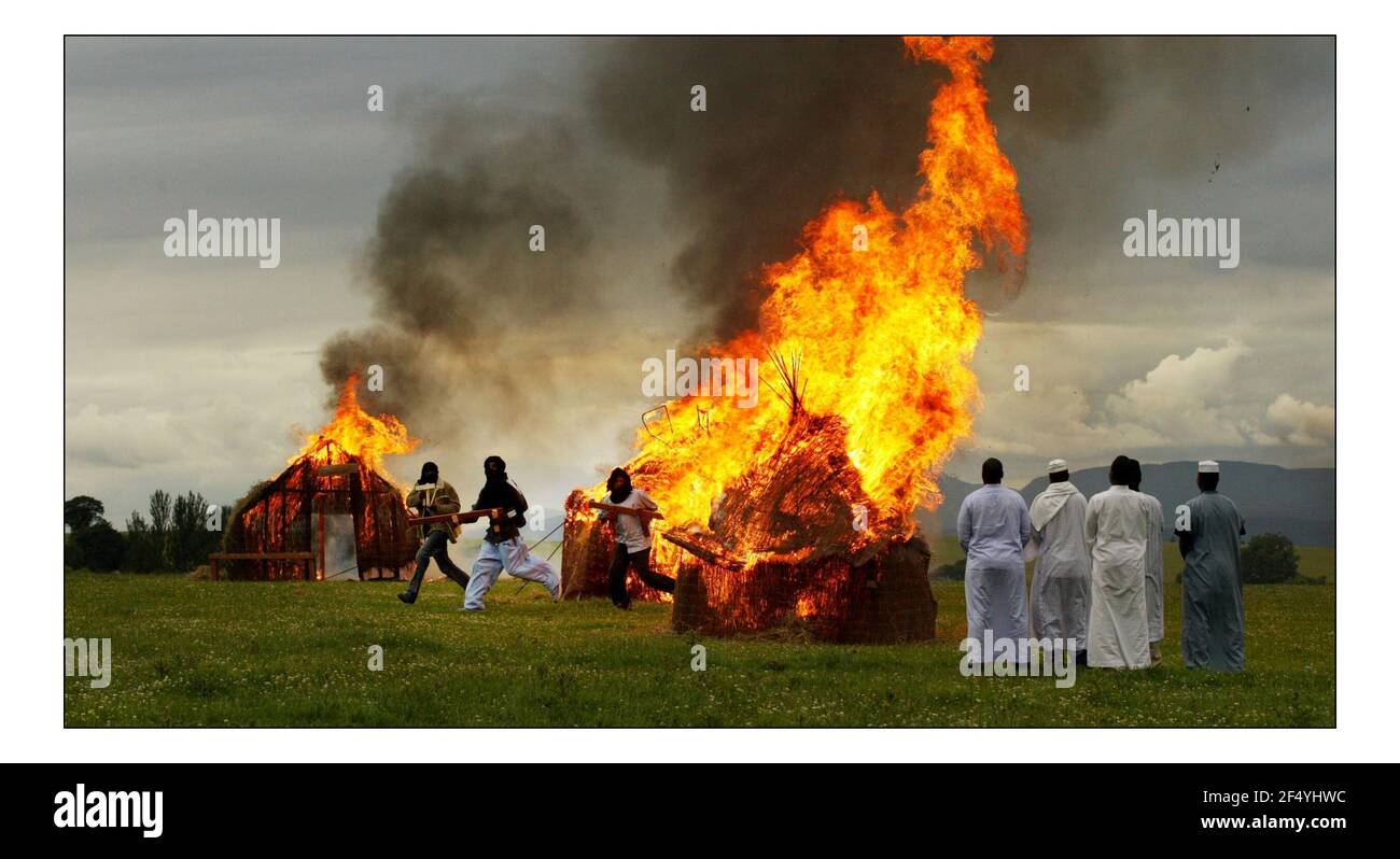 Darfur Survivors Re enact il bruciare e la distruzione di a. Mock villaggio vicino alla milizia Janjaweed su una collina che si affaccia Il complesso di Gleneagles dove i leader del G8 saranno meeting.pic David Sandison 5/7/2005 Foto Stock