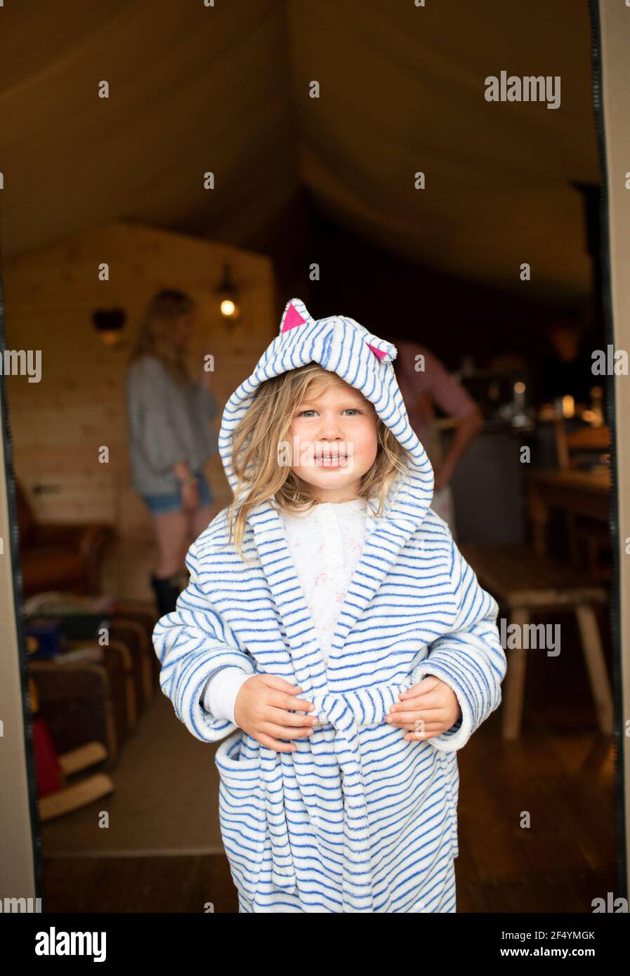 Ritratto ragazza carina in accappatoio a righe nella porta della cabina Foto Stock