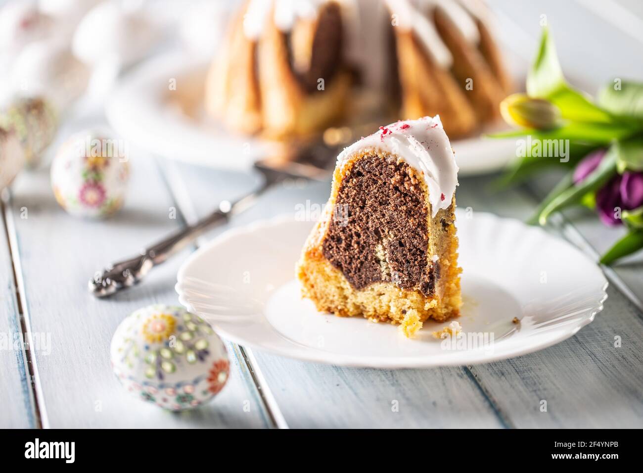Un pezzo tagliato di torta di marmo pasquale su un piatto bianco. Foto Stock