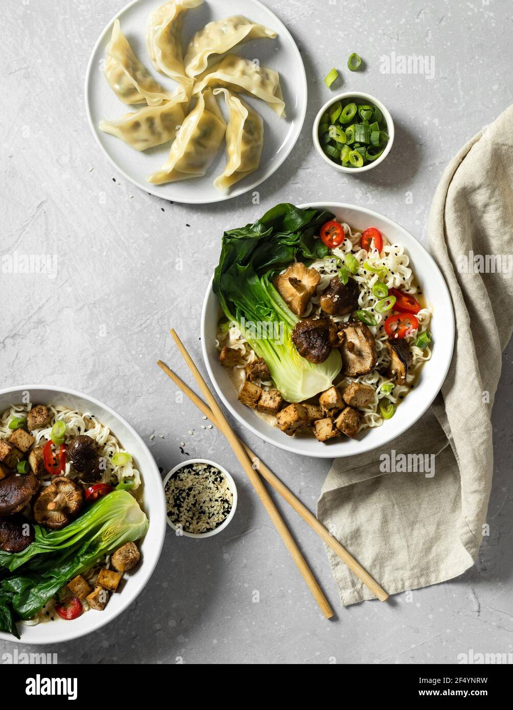 Deliziosa zuppa di ramen vegano con tagliatelle di ramen, funghi shiitake, peperoncino piccante, choi di pak al vapore e fritti in pezzi di tofu di salsa di soia, lato di gnocchi Foto Stock
