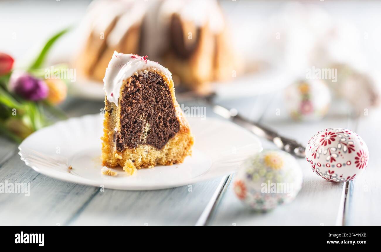 Un pezzo tagliato di torta di marmo pasquale su un piatto bianco. Foto Stock