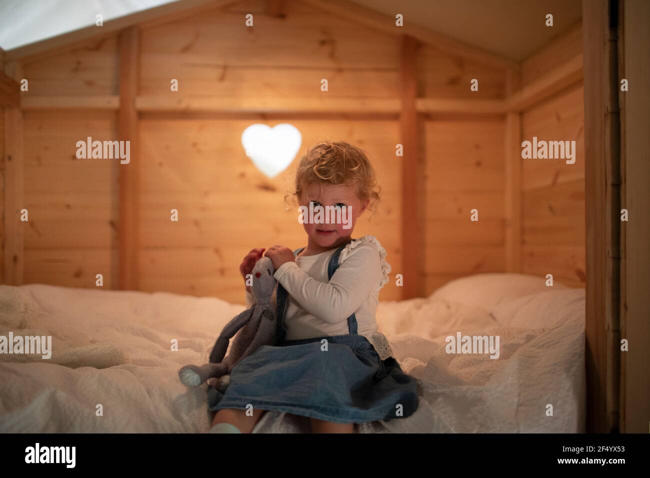 Ritratto ragazza carina con animale ripieno a letto Foto Stock