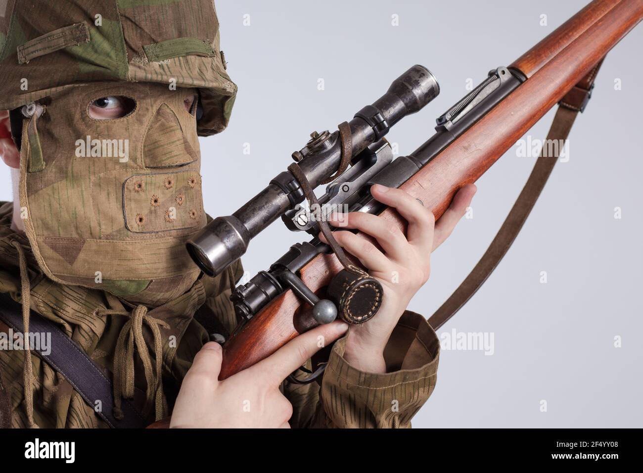 Attore uomo in una vecchia divisa militare e camuffamento cecchino abbigliamento da markman di un soldato dell'esercito tedesco durante la seconda guerra mondiale Foto Stock