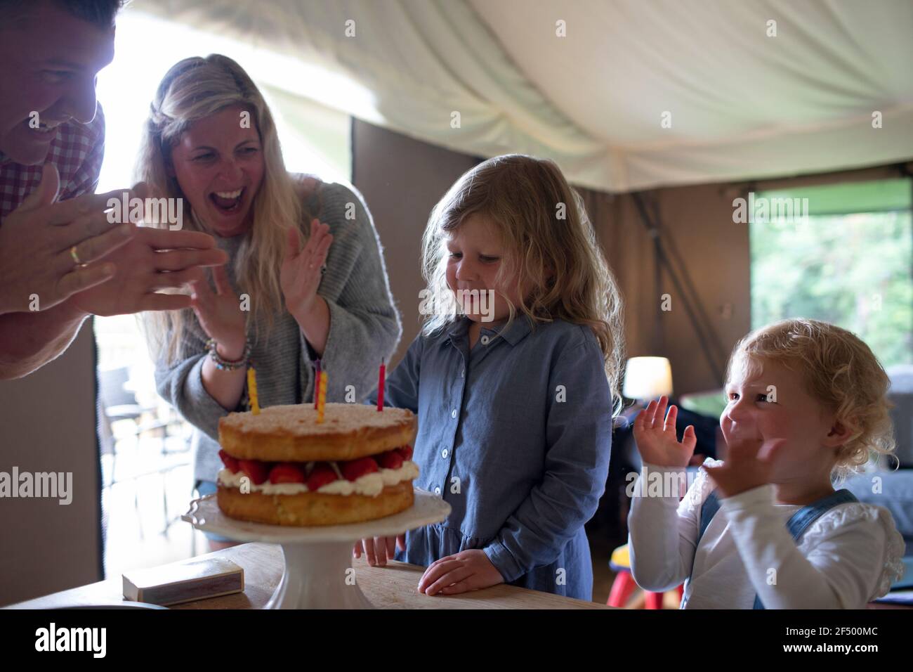 Buona famiglia che festeggia il compleanno con la torta di fragole Foto Stock