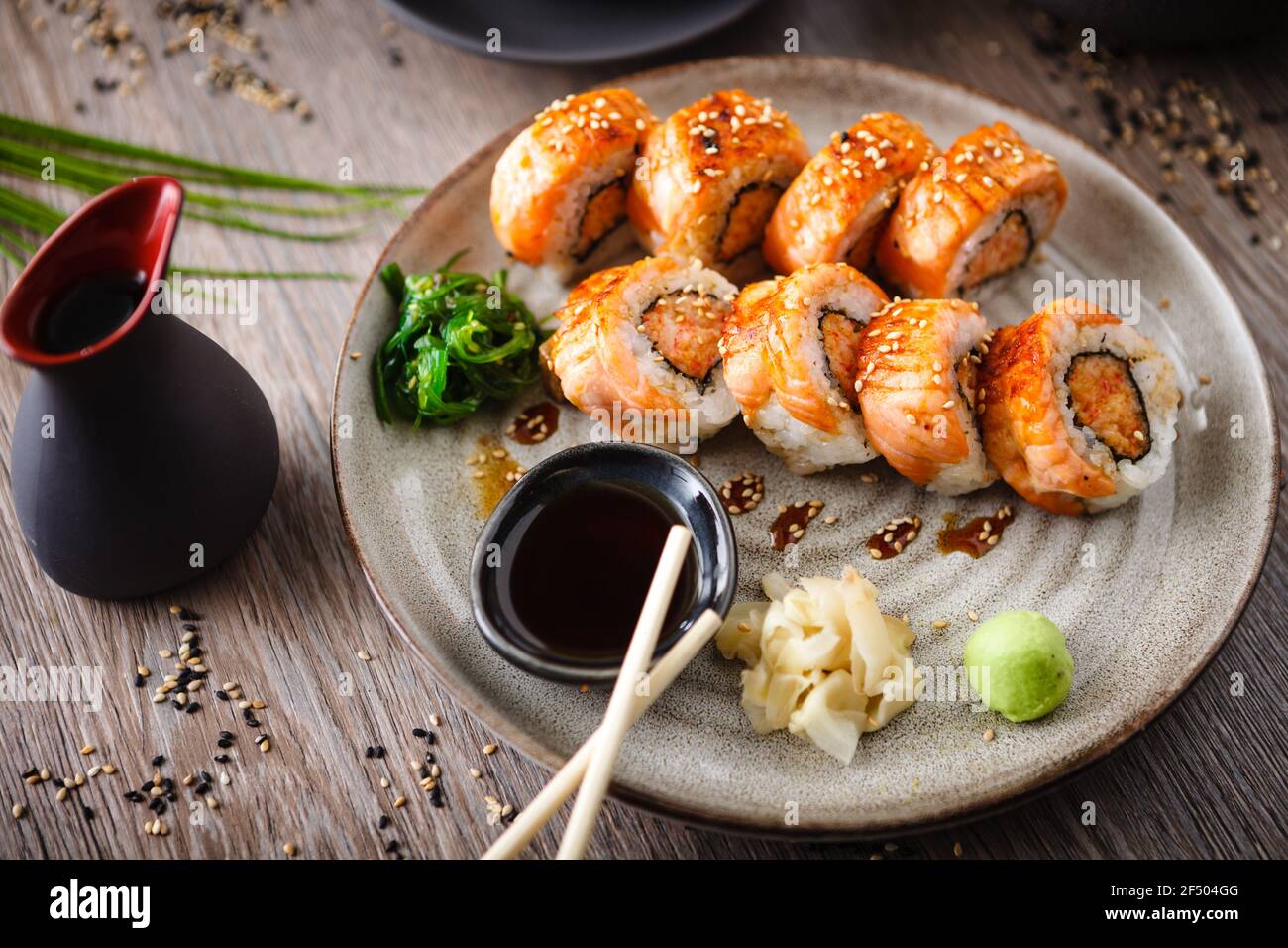 Panini al sushi maki al forno con salmone, granchio e salsa piccante su un  piatto con