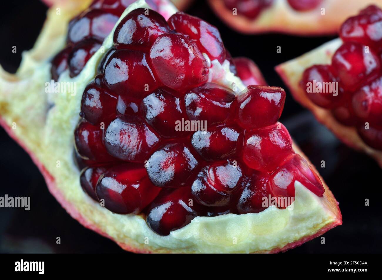 Melograno su sfondo nero. Vari melograni maturi e melograno aperto Foto Stock