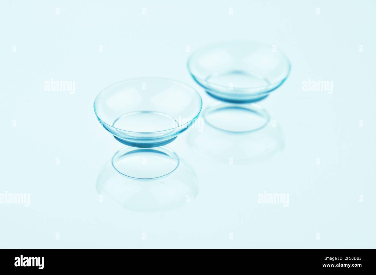 Lenti a contatto su sfondo chiaro. Lenti a contatto perfettamente ritoccate su sfondo azzurro. Foto Stock