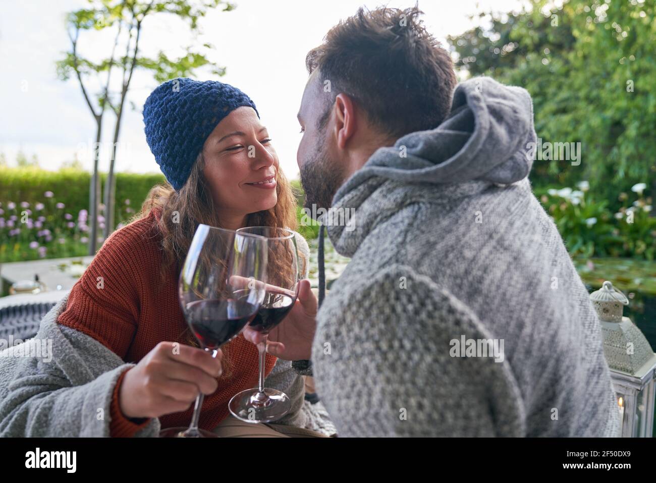 Affettuosa coppia romantica che beve vino rosso sul patio Foto Stock