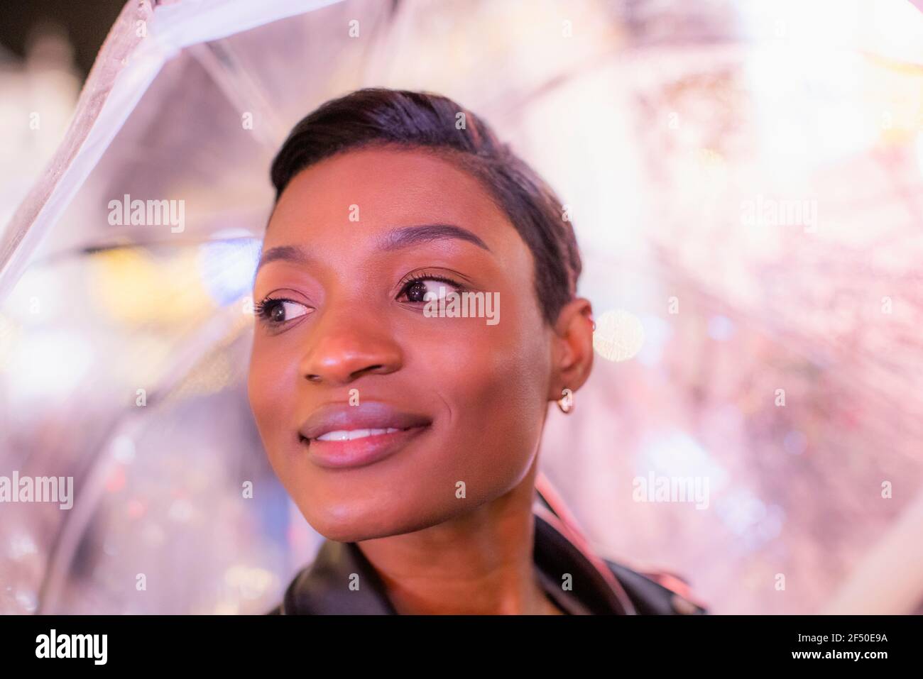 Primo piano bella giovane donna con capelli neri corti sotto ombrello Foto Stock