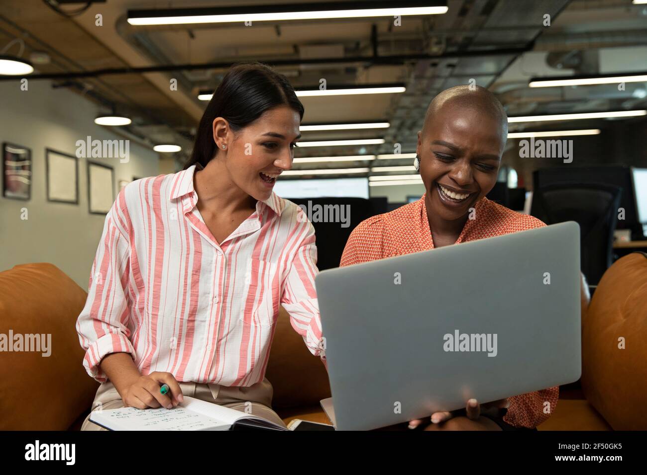 Donna d'affari felice che lavora in un computer portatile in ufficio Foto Stock