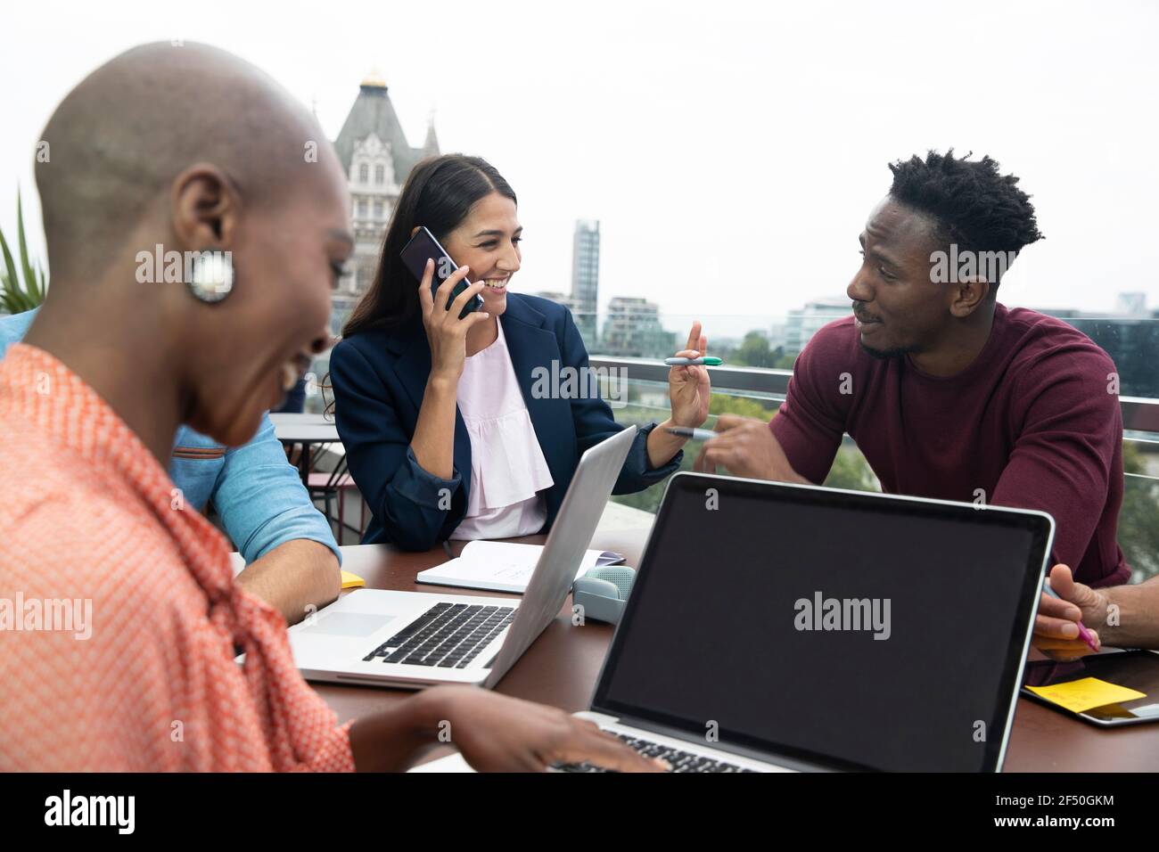 Gli uomini d'affari che parlano e lavorano con i computer portatili sul balcone Foto Stock