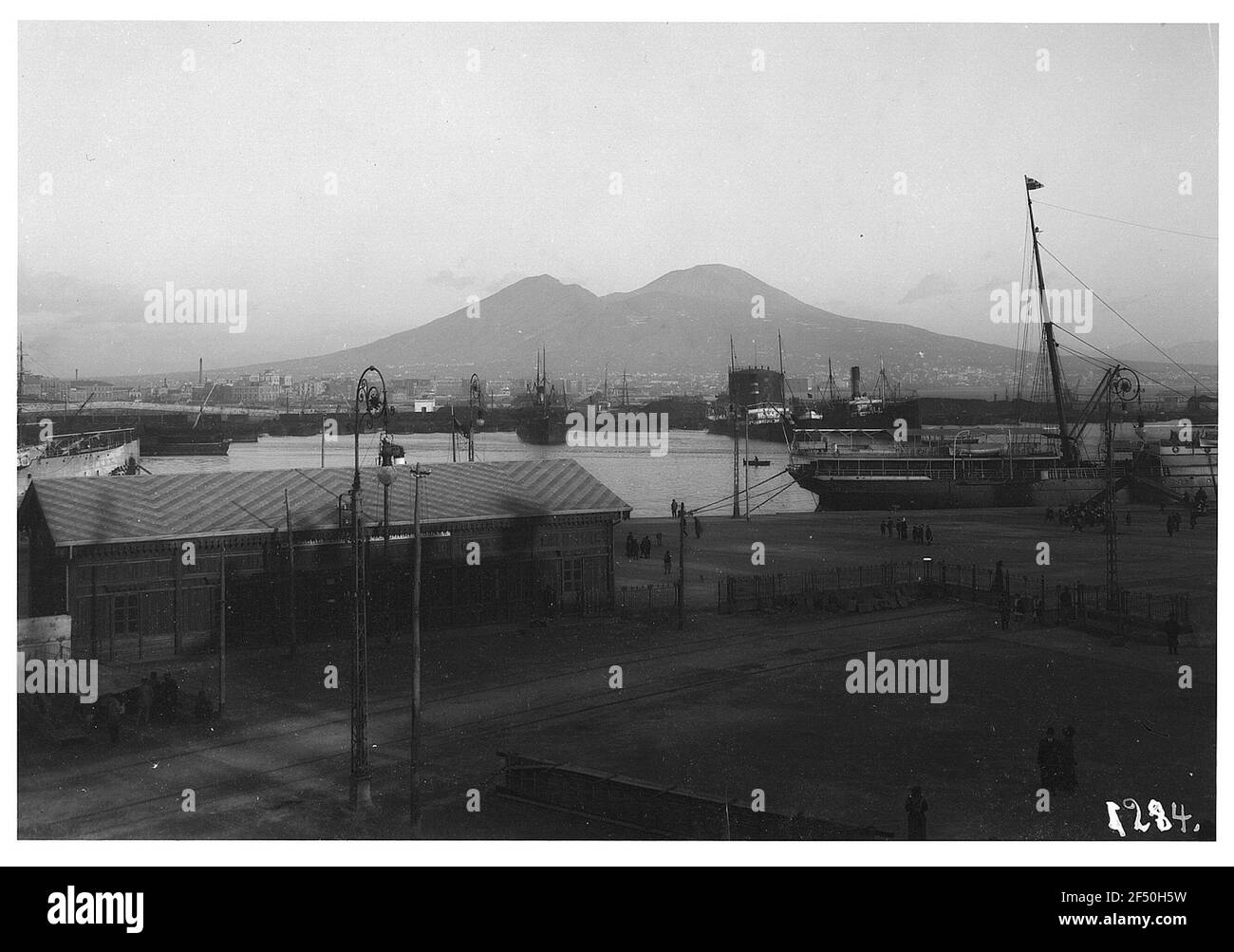 Napoli. Vista sul porto con edifici, navi passeggeri, barche e marinai Foto Stock