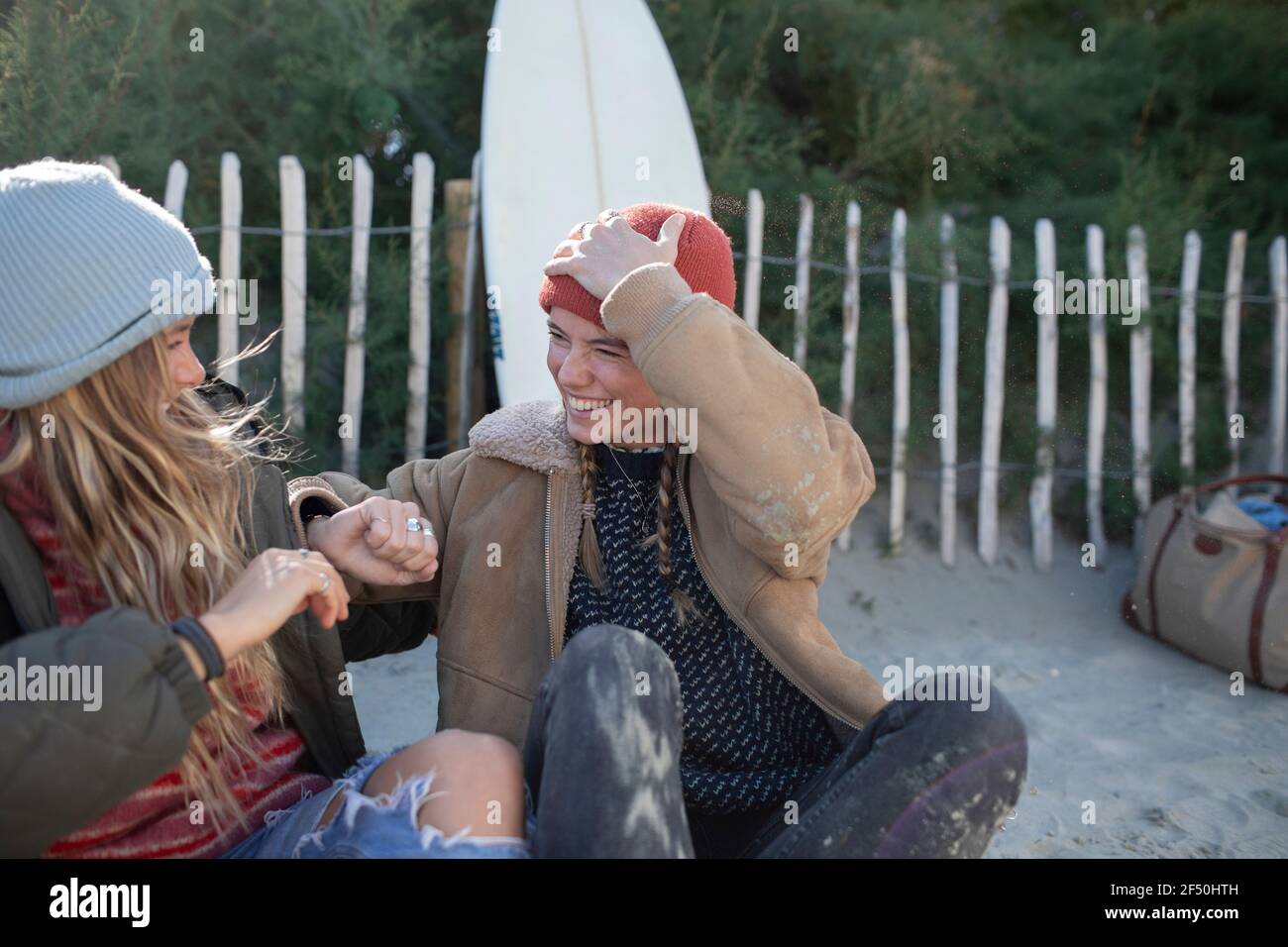 Felici giovani donne amici che ridono sulla spiaggia Foto Stock