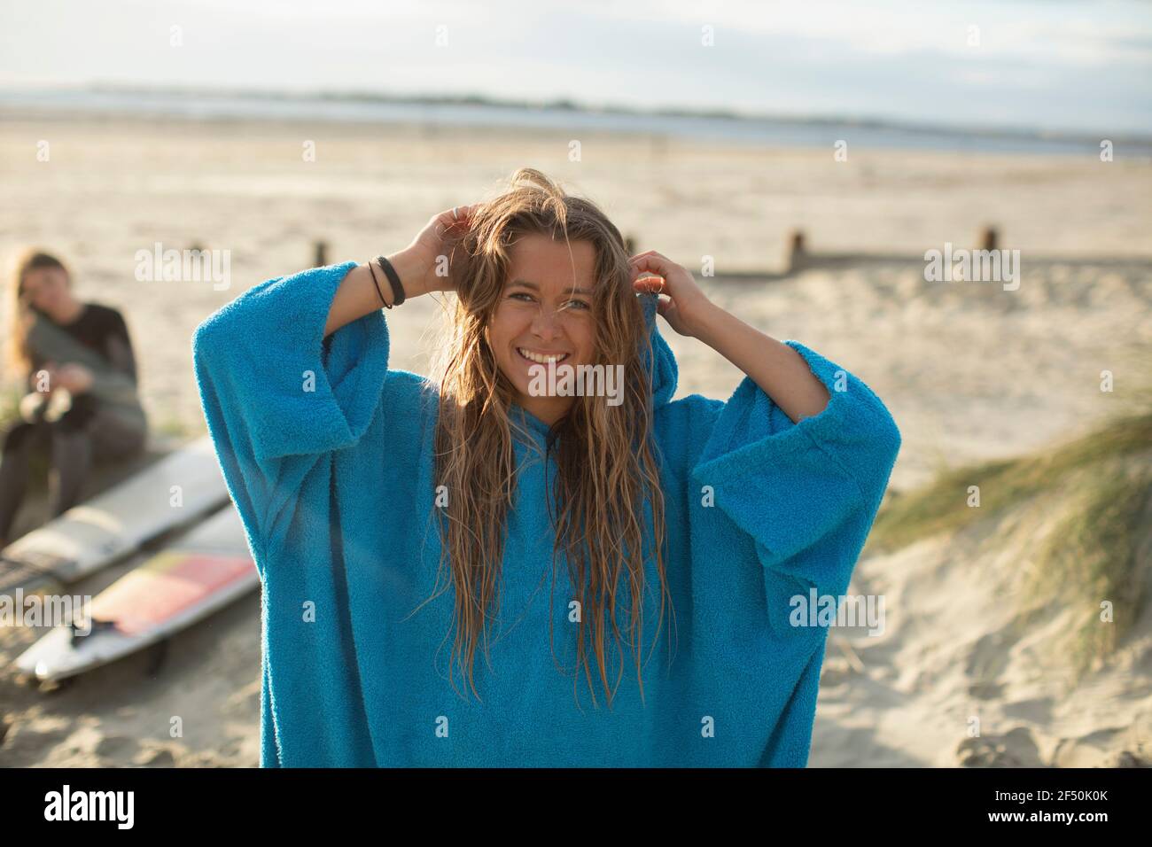 Ritratto Felice giovane surfista con capelli bagnati sul sole spiaggia Foto Stock