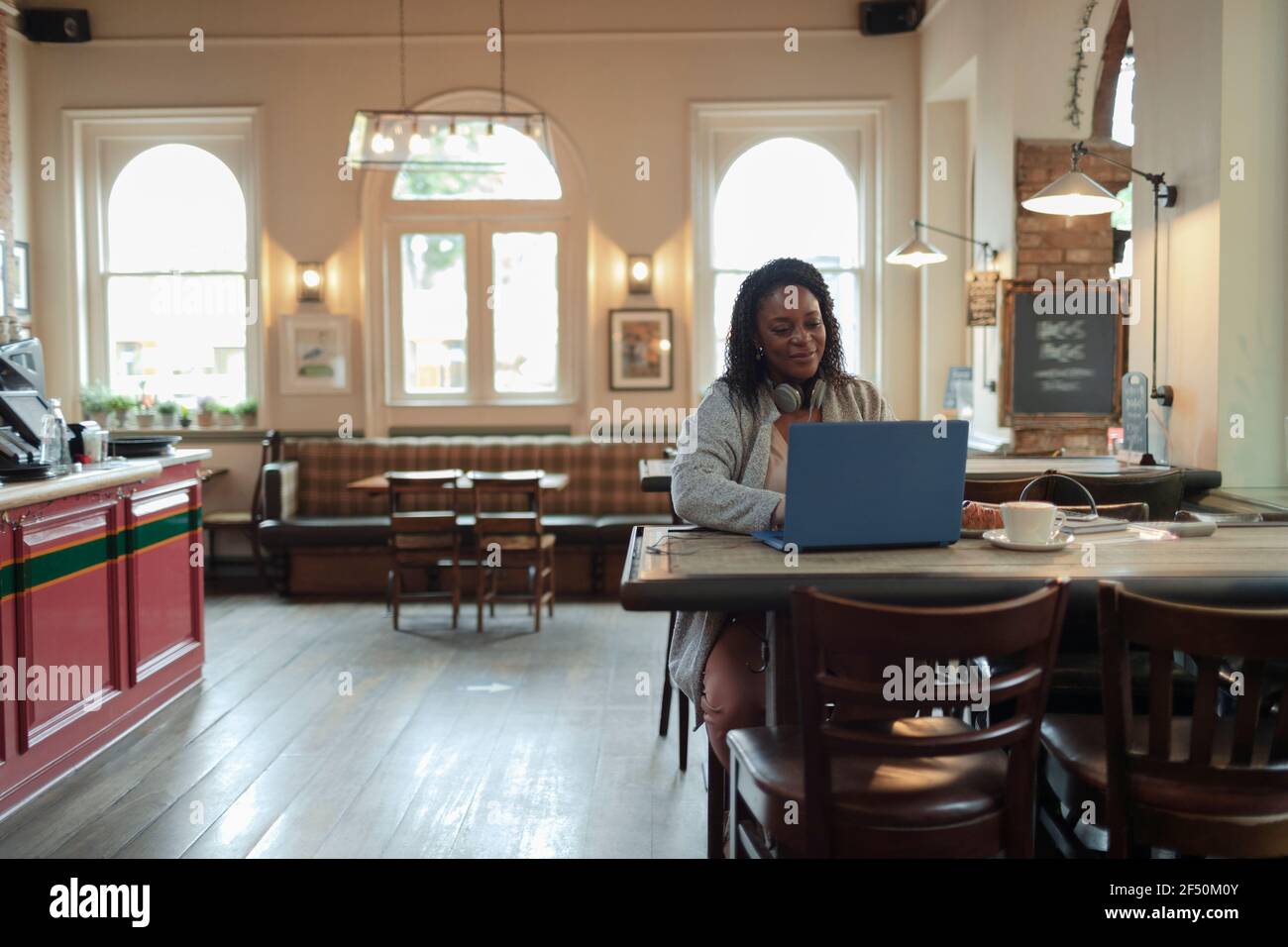 Donna d'affari che lavora al computer portatile al tavolo del caffè Foto Stock