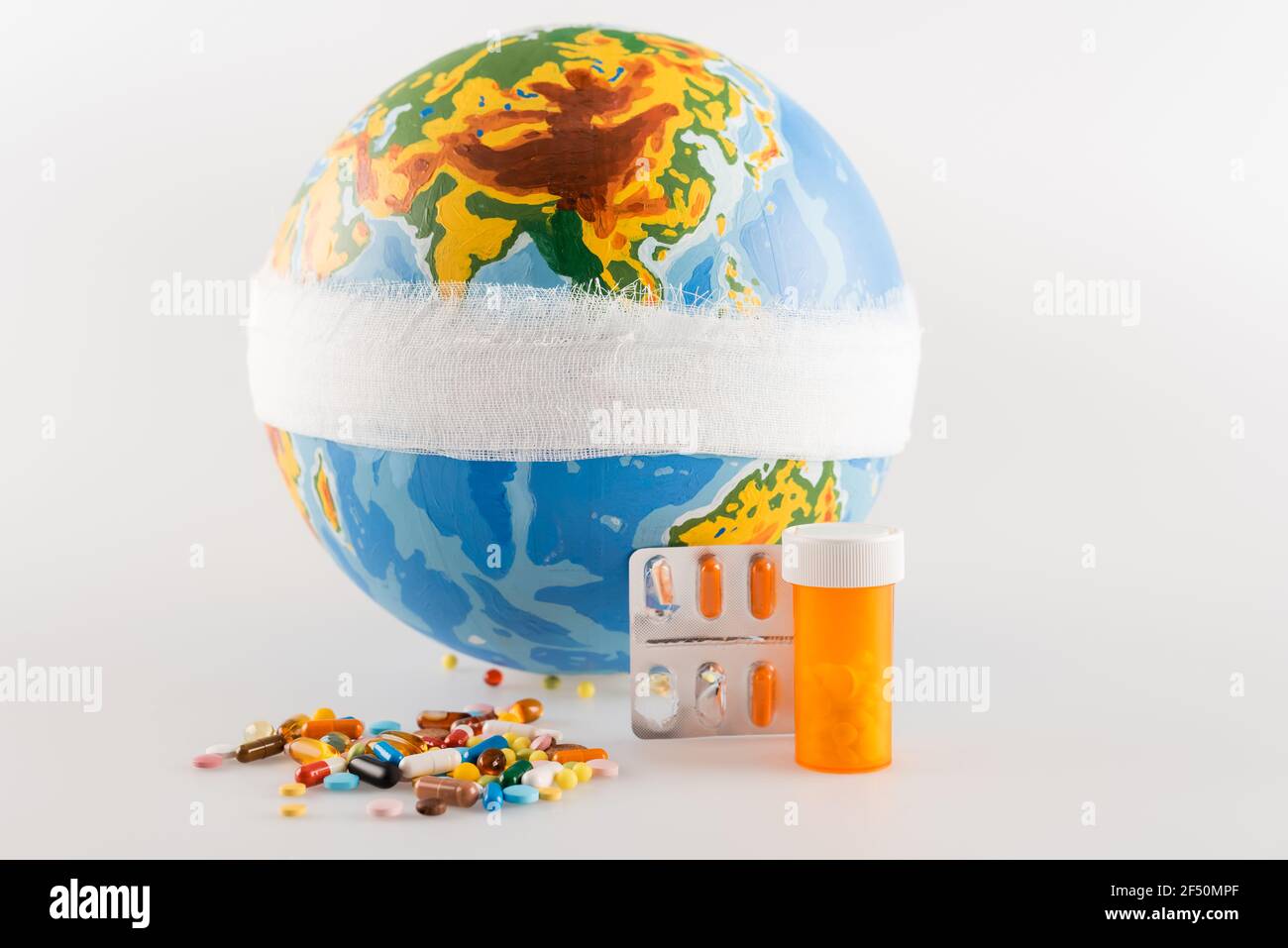 globo bendato vicino ai farmaci su sfondo grigio, concetto di ecologia Foto Stock