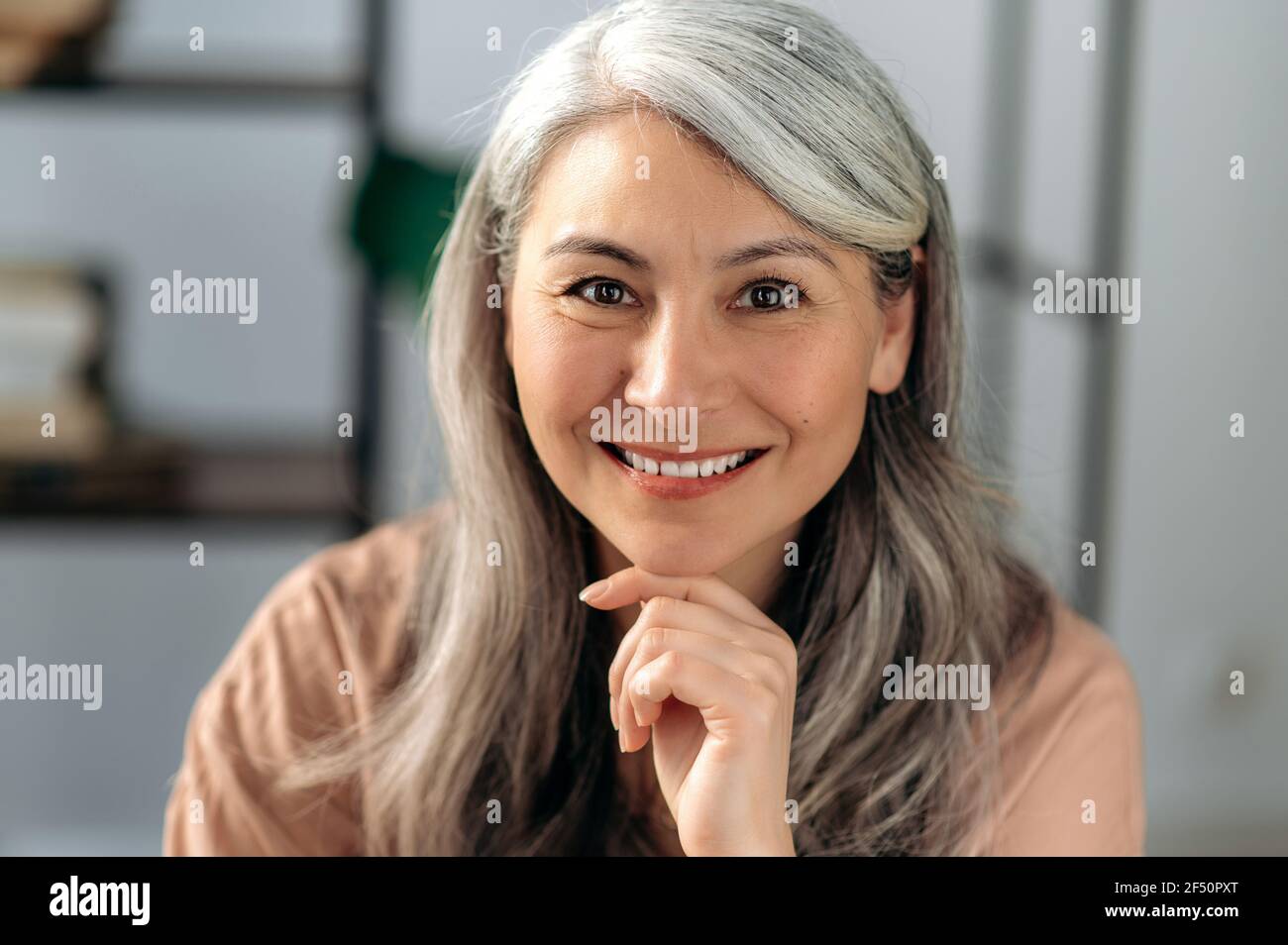 Primo piano ritratto di una bella donna d'affari asiatica matura di successo, una donna con capelli grigi sicura in un abbigliamento casual elegante, guardando direttamente la fotocamera con un sorriso amichevole Foto Stock