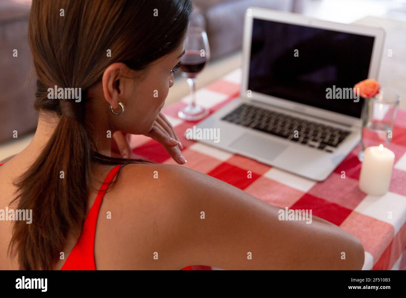 Donna caucasica seduta dalla scrivania con una chat video computer portatile e sorridente Foto Stock
