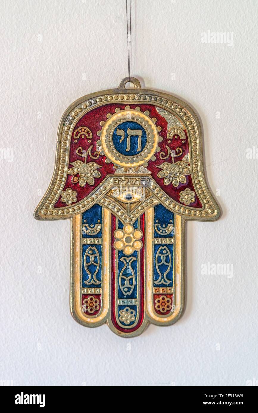 Hamsa Ebraica o Khamsa - mano di Dio, un simbolo medio-orientale per la fortuna che pende da un muro Foto Stock