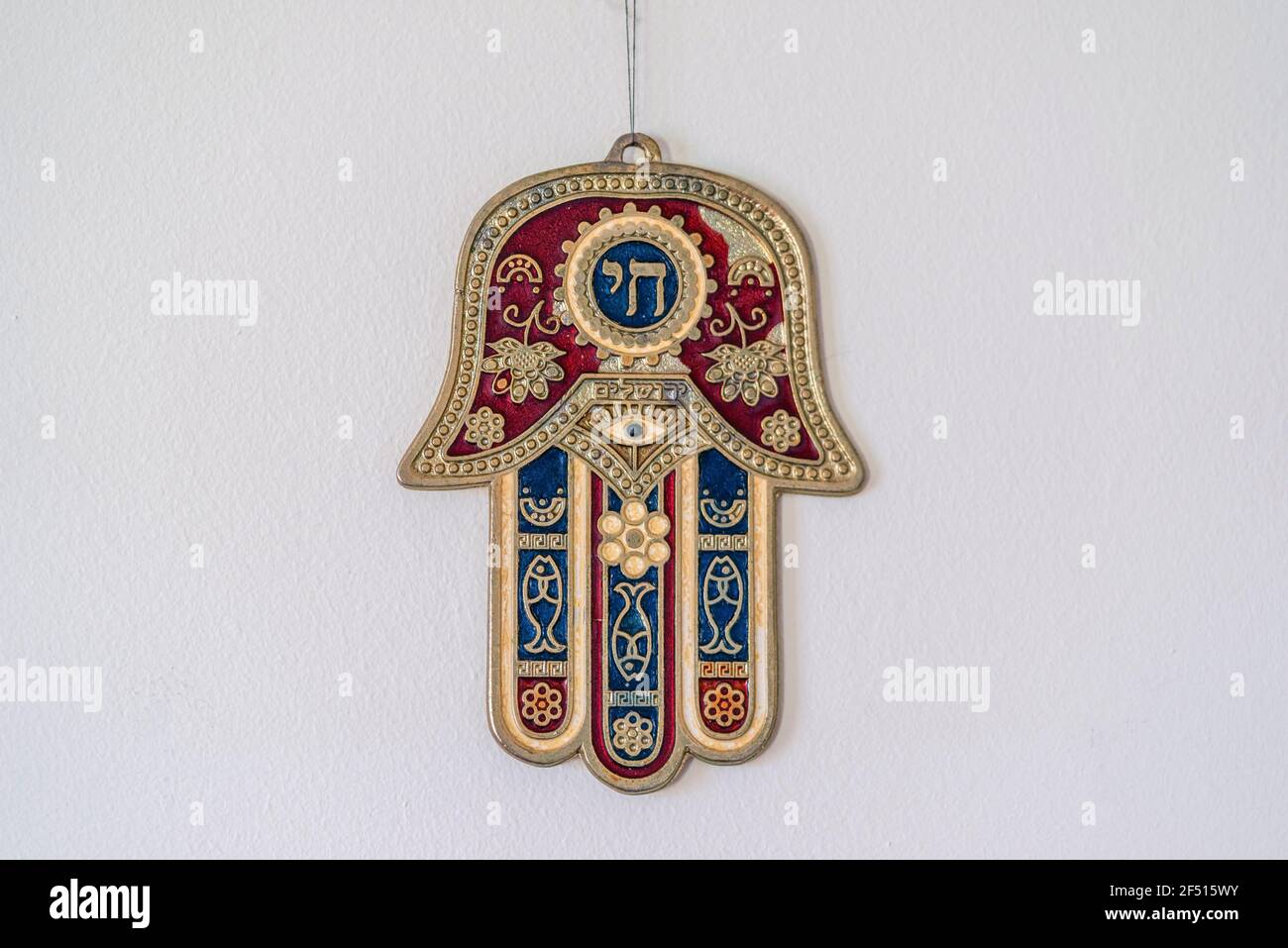 Hamsa Ebraica o Khamsa - mano di Dio, un simbolo medio-orientale per la fortuna che pende da un muro Foto Stock