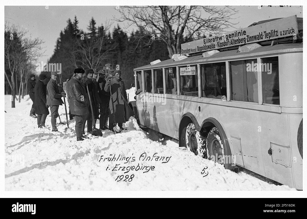 Sassonia, Monti Osterz. Kraftomnibus la linea di veicoli express Dresden - Zinnwald (-teplitz) e indietro, adagiato sulla neve, accanto al gruppo di uomini con lame Foto Stock