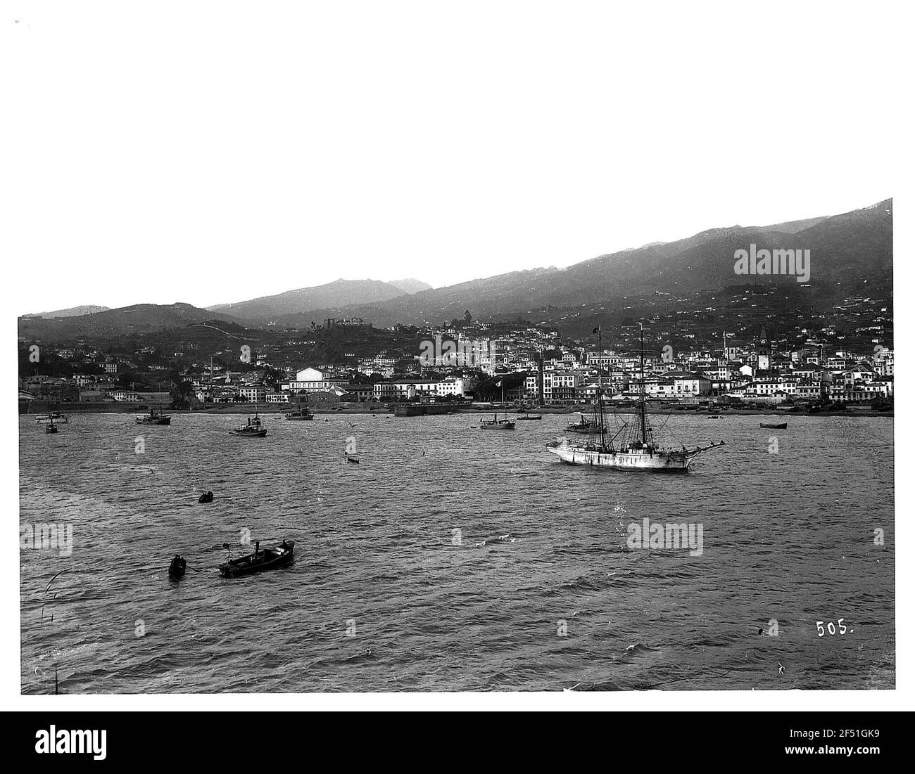 Funchal, Madeira. Vista dal lungomare della città e del porto con barche e due maestri Foto Stock