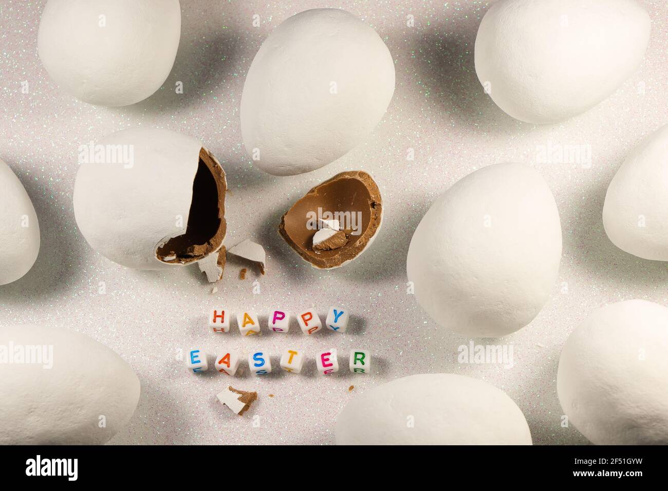 Happy Easter Chocolate Candy Eggs on Snowy White Foto Stock