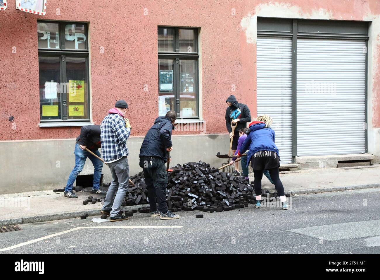 Die jungen Bewohner eines eines Gründerzeithauses schaufeln abgekippte Braunkohlebrichetts in den Kohlekeller des Hauses. Görlitz, 23.3.2021 Foto Stock