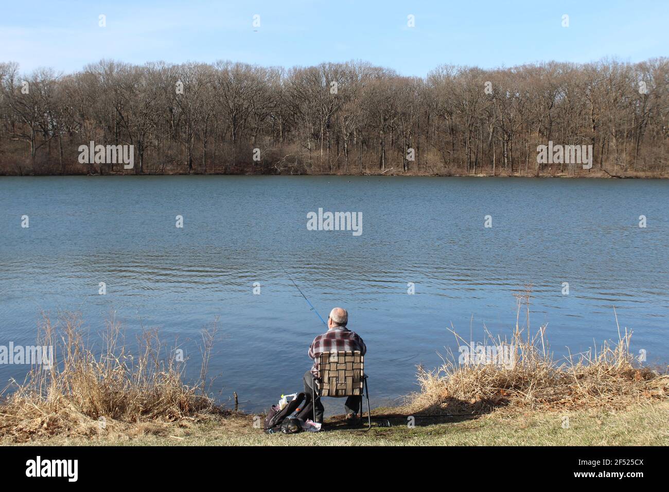 Uomo in una camicia di flanella pesca al lago Horsetail a Palos Park, Illinois Foto Stock