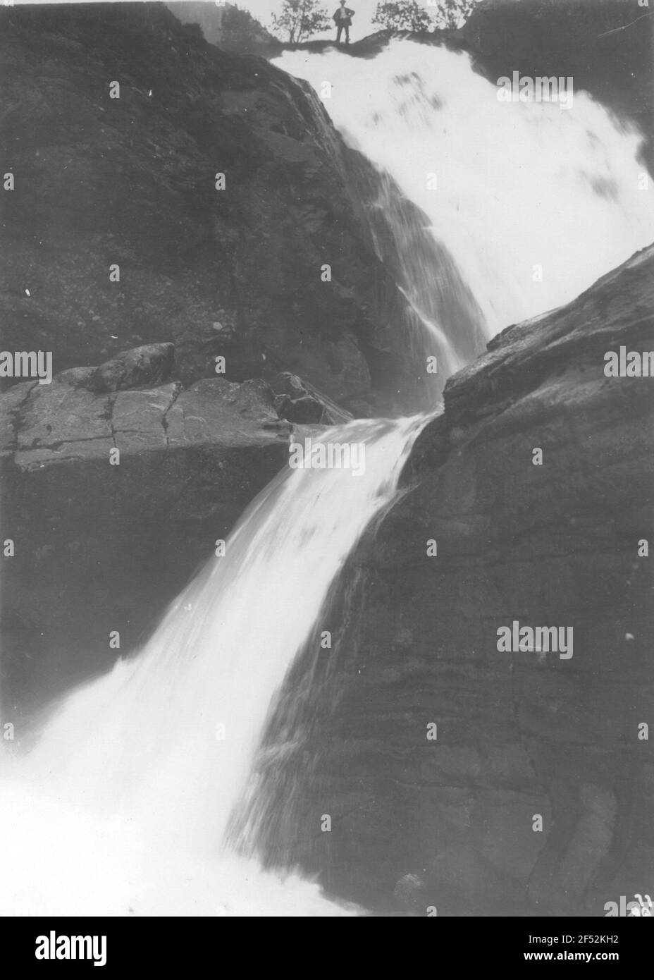 A Merok (Norvegia). Su grandi rocce ripide in discesa cascata, sul corso superiore si erge un solo gentleman Foto Stock A Merok (Norvegia). Su grandi rocce ripide in discesa cascata, sul corso superiore si erge un solo gentleman Foto Stock