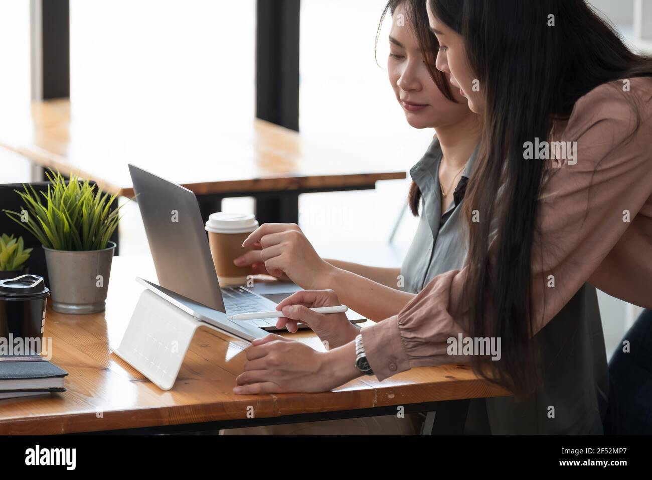 Primo piano due donne che discutono progetti di affari in un caffè mentre hanno caffè. Concetto di startup, idee e tempesta di cervello. Foto Stock