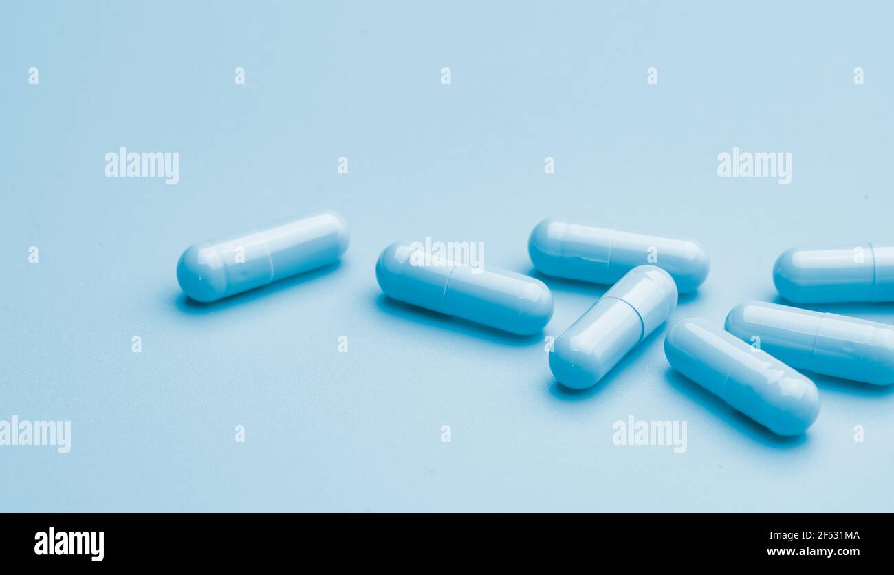 Capsule blu su sfondo blu. Banner farmacia online. Gruppo delle pillole della capsula. Industria farmaceutica. Sviluppo di nuovi farmaci e ricerca di nuovi farmaci Foto Stock