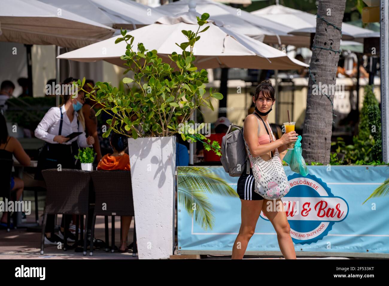 Miami Beach turista andare alla spiaggia con borse e. bere in mano Foto Stock