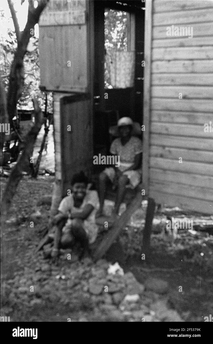 Foto di viaggio Caraibi. Trinidad. Due locali sulle scale per la loro casa di legno Foto Stock
