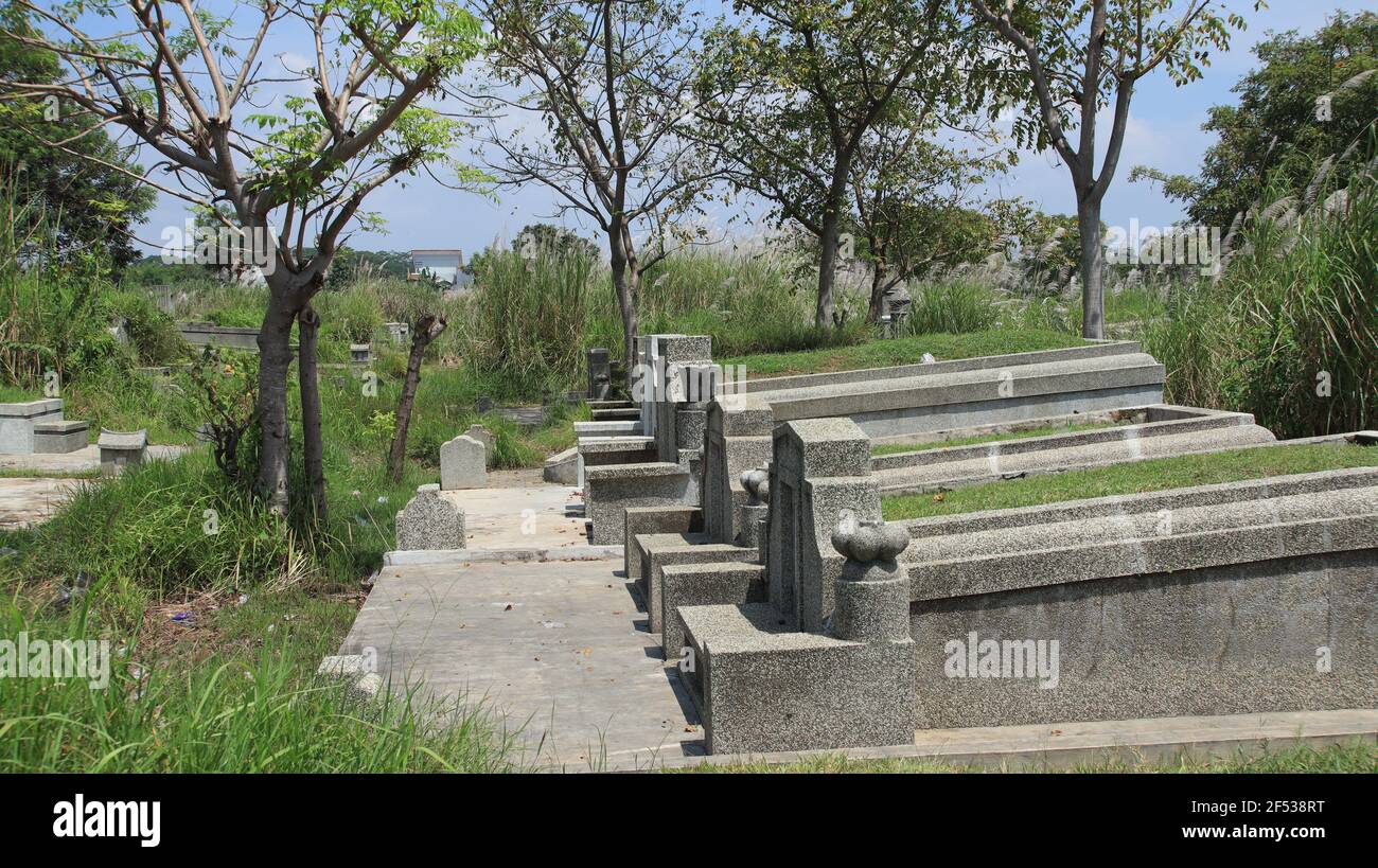 Cultura cinese tradizionale tombe in cemento con il nome cinese memoriale è nel cimitero. Pekalongan, Indonesia, 19 marzo 2021 Foto Stock