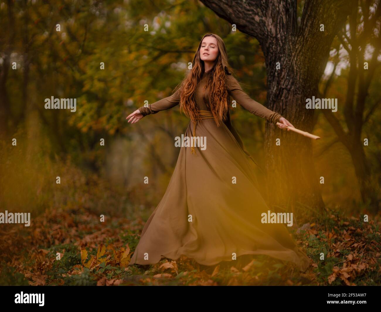 Donna rossa in abito che cammina in fantasy fiaba foresta Foto Stock