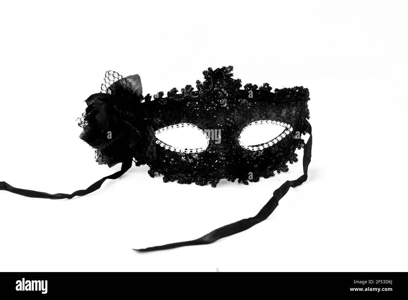 Una maschera veneziana nera fantasia con pizzo e diamantati per carnevale, fasching o mardi gras isolato su uno sfondo bianco. Foto Stock