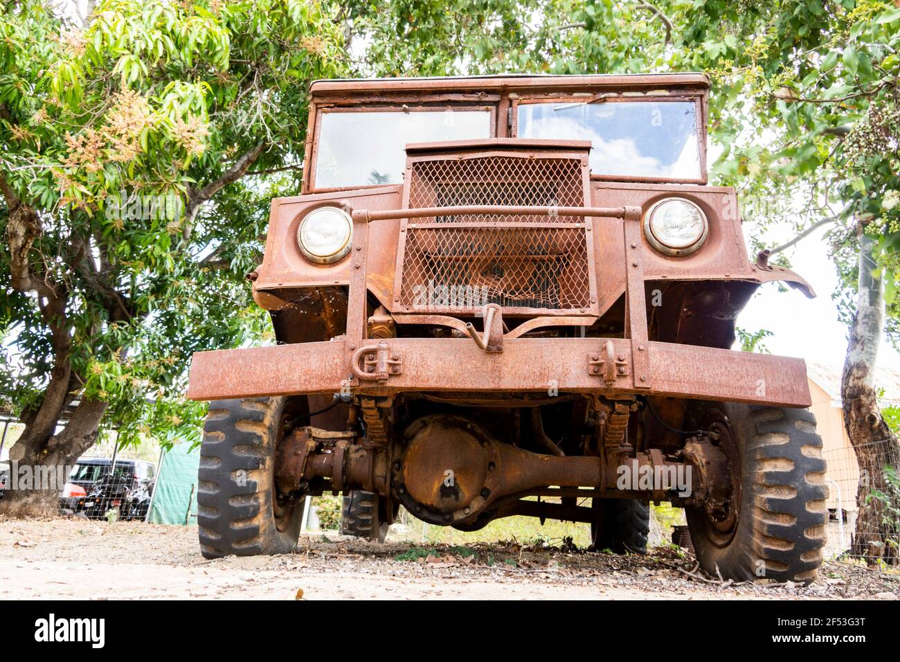 Una vista bassa di un vecchio camion arrugginito di Blitz tempo di guerra lasciato sotto alcuni alberi in attesa di restauro per farlo funzionare. Foto Stock