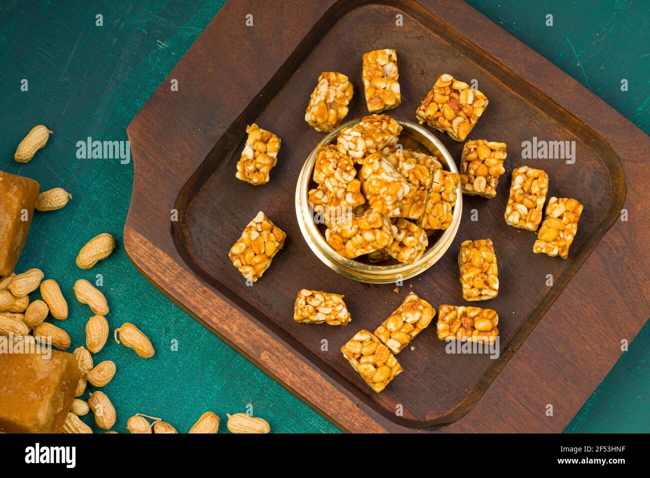 Bar di arachidi, croccante dolce bar di arachidi che è molto sano snack, organizzato in una base di legno con un po 'di arachidi e la gelificazione su la texture verde scuro sul retro Foto Stock