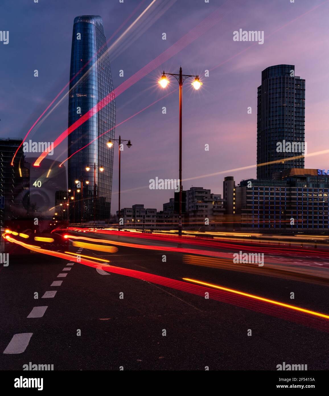 Il Boomerang, un Blackfriars di notte da Blackfriars Bridge, con strisce sfocate di auto e autobus di luce sentieri in primo piano Foto Stock