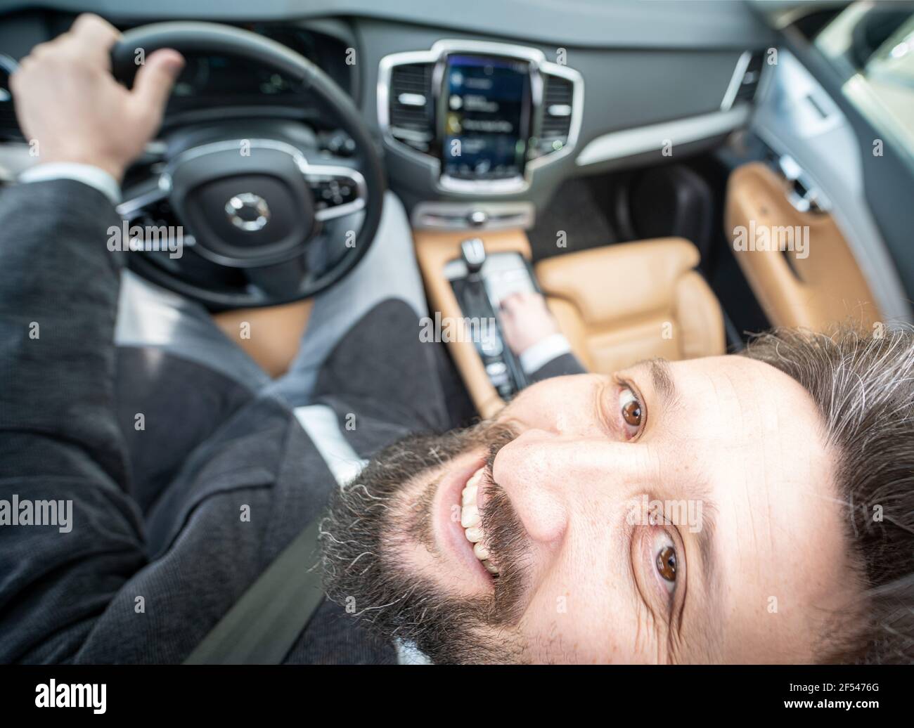 Divertente grandangolo di un driver maschile in auto di lusso Foto Stock