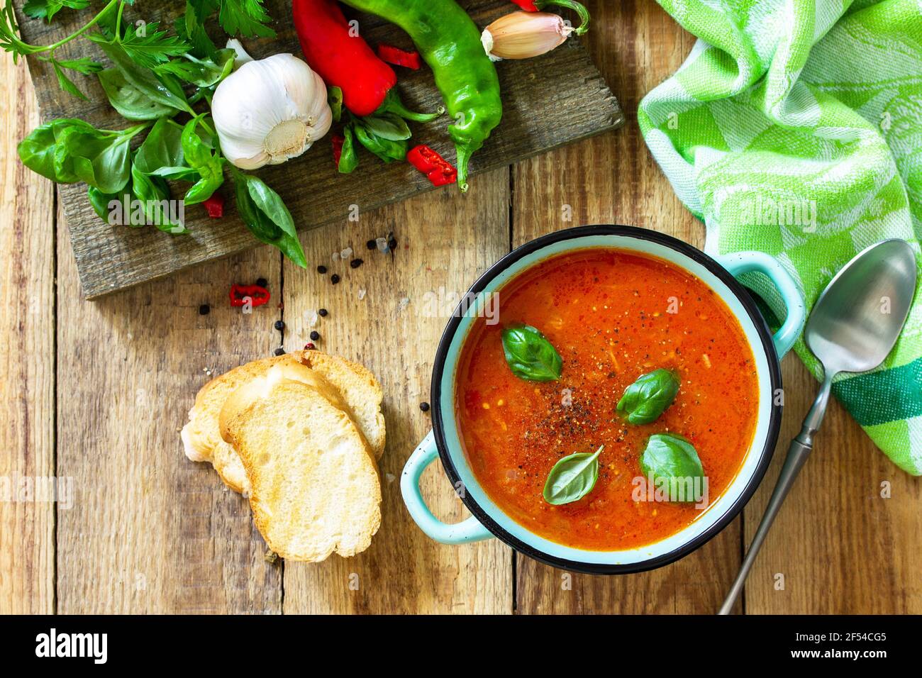Il concetto di cibo sano e dietetico, piatto vegetariano. Zuppa di pomodoro o zuppa di gazpacho con crostini su un tavolo rustico in legno. Vista dall'alto in piano. Foto Stock