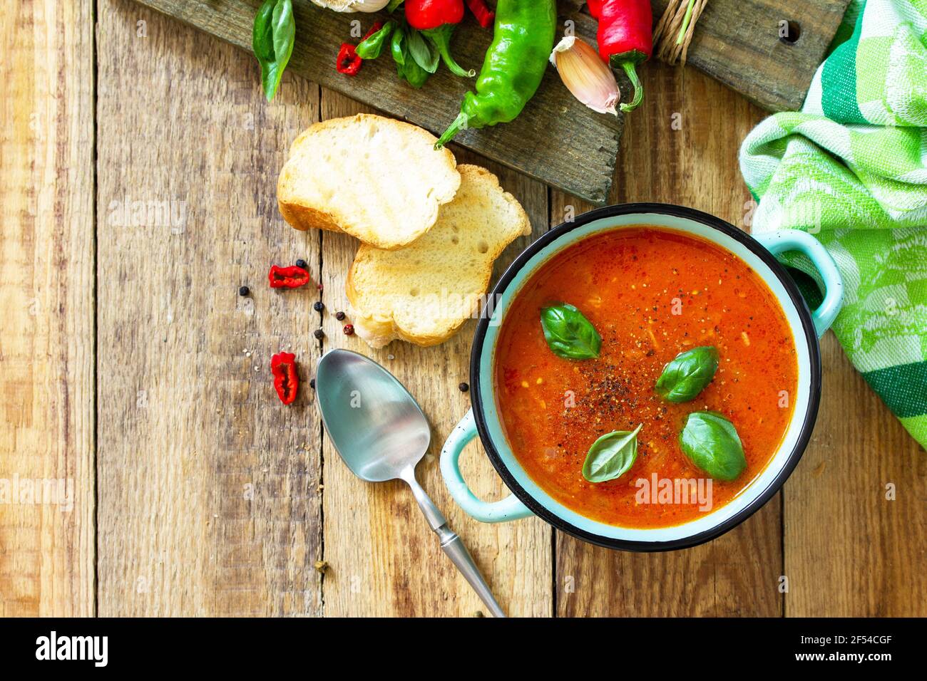 Il concetto di cibo sano e dietetico, piatto vegetariano. Zuppa di pomodoro o zuppa di gazpacho con crostini su un tavolo rustico in legno. Foto Stock