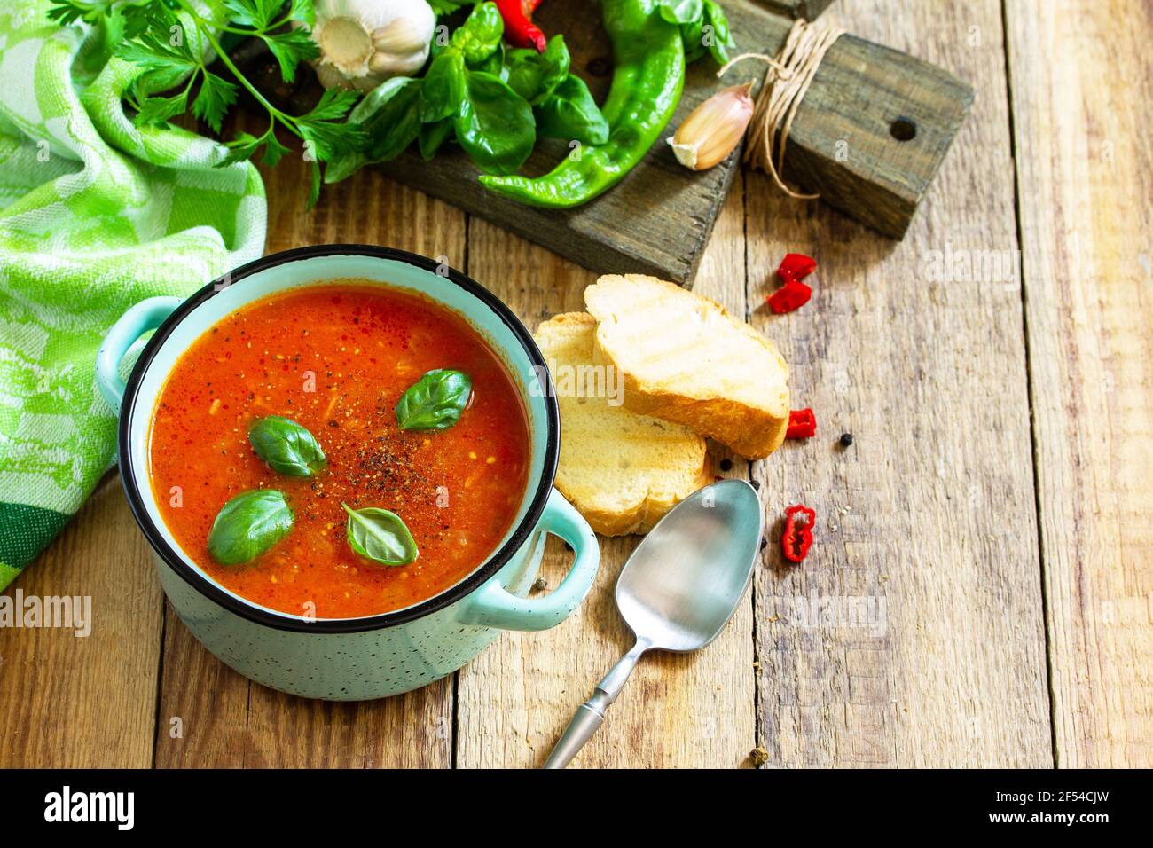 Il concetto di cibo sano e dietetico, piatto vegetariano. Zuppa di pomodoro o zuppa di gazpacho con crostini su un tavolo rustico in legno. Spazio di copia. Foto Stock