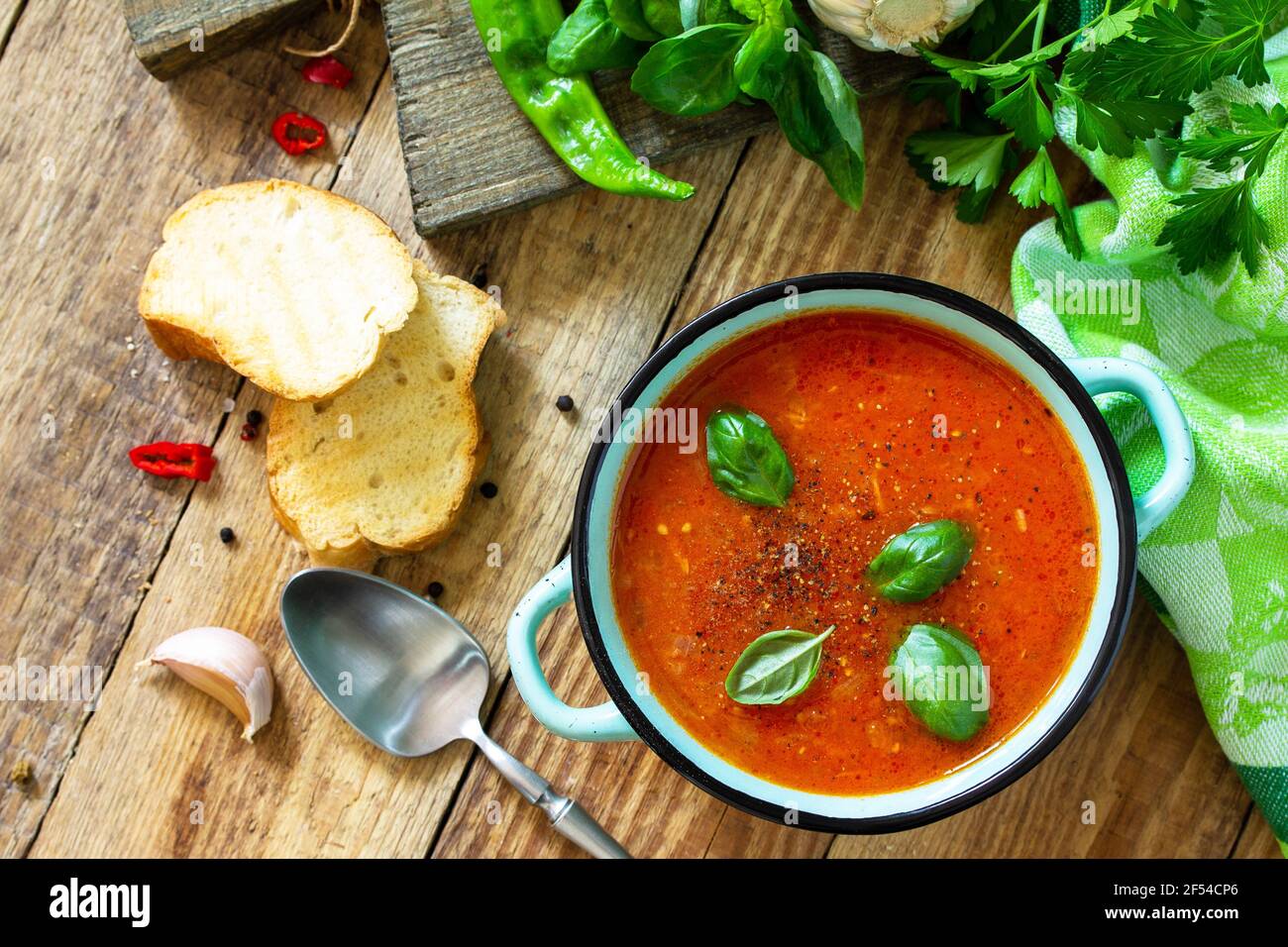 Il concetto di cibo sano e dietetico, piatto vegetariano. Zuppa di pomodoro o zuppa di gazpacho con crostini su un tavolo rustico in legno. Foto Stock