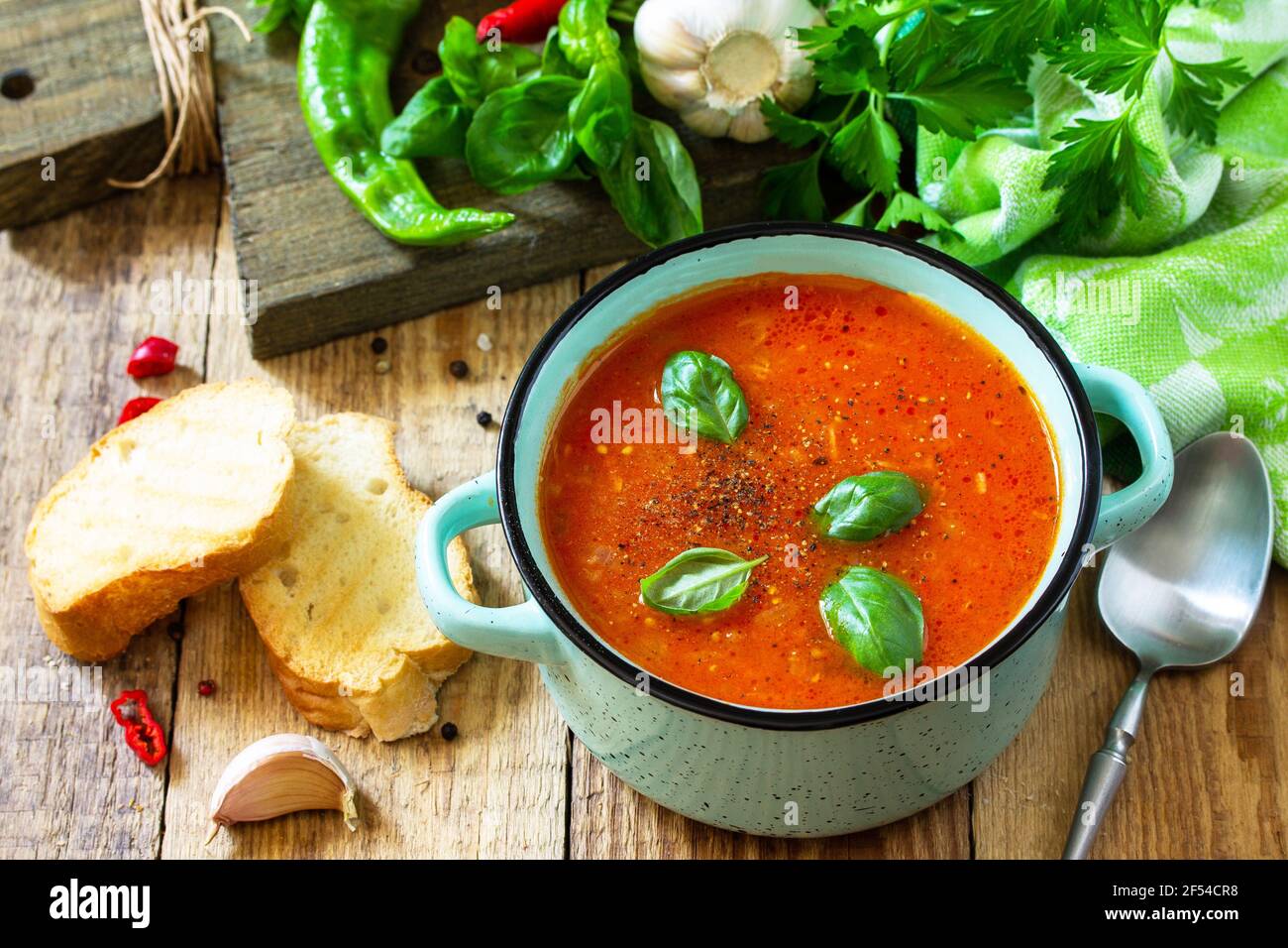 Il concetto di cibo sano e dietetico, piatto vegetariano. Zuppa di pomodoro o zuppa di gazpacho con crostini su un tavolo rustico in legno. Foto Stock