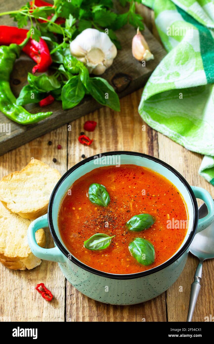Il concetto di cibo sano e dietetico, piatto vegetariano. Zuppa di pomodoro o zuppa di gazpacho con crostini su un tavolo rustico in legno. Foto Stock